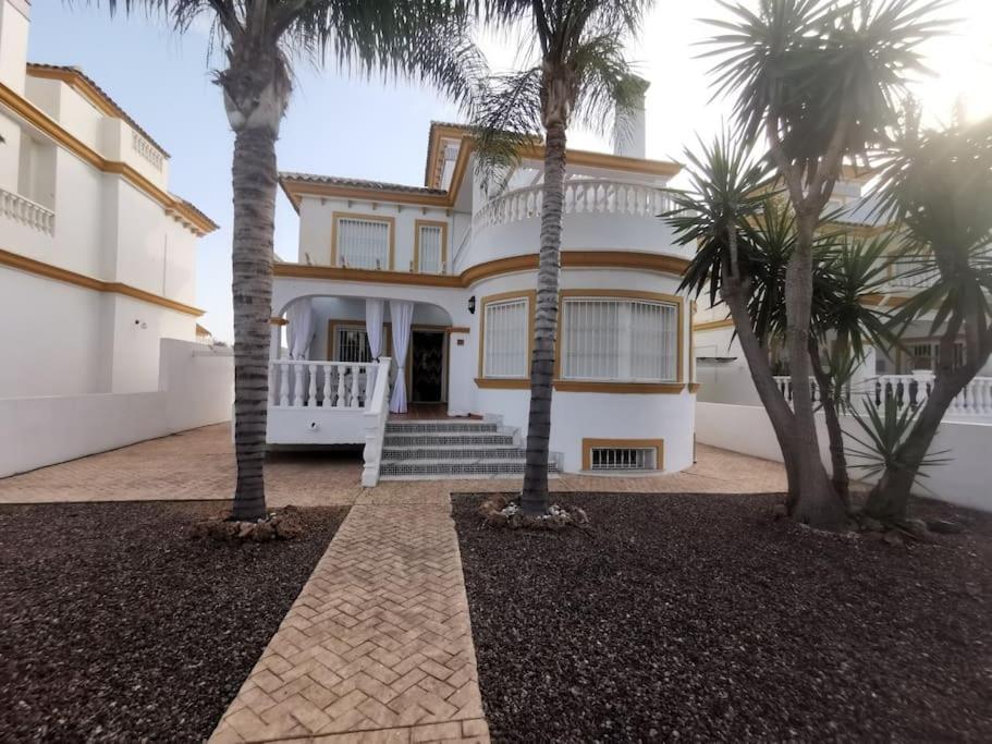 a house with palm trees in front of it at Luxury Paradise Beach Villa in Vera