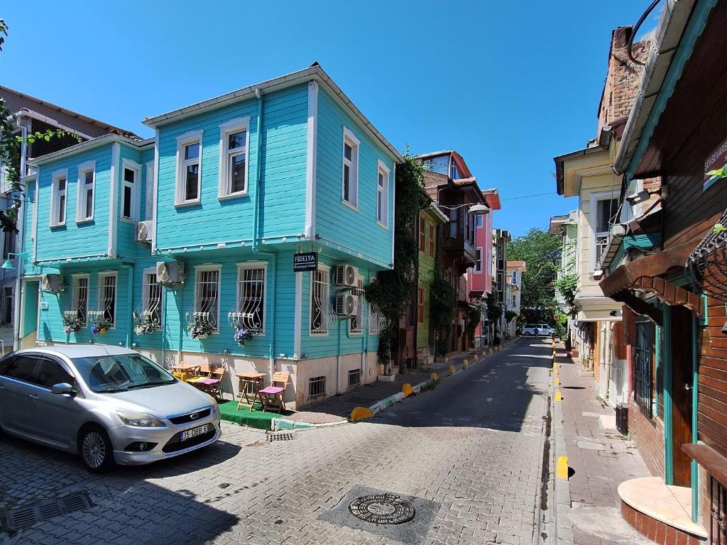 a street with colorful houses and a car on the road at Fidelya Boutique Hotel in Istanbul