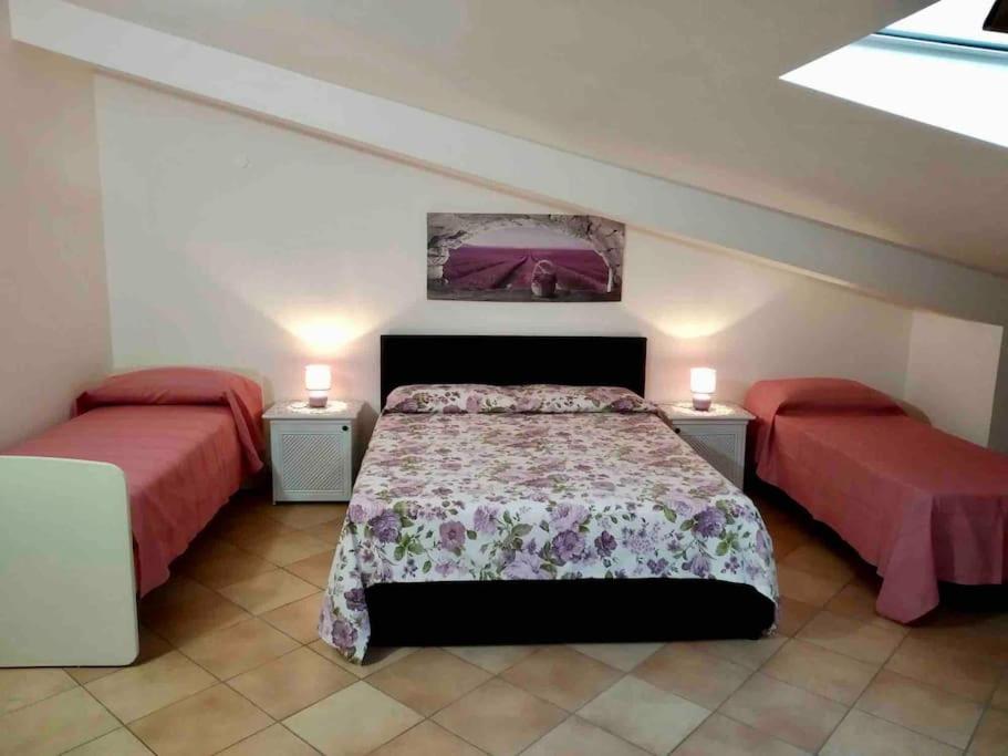 um quarto com duas camas e dois candeeiros em Incantevole attico con grande terrazza em Anzio