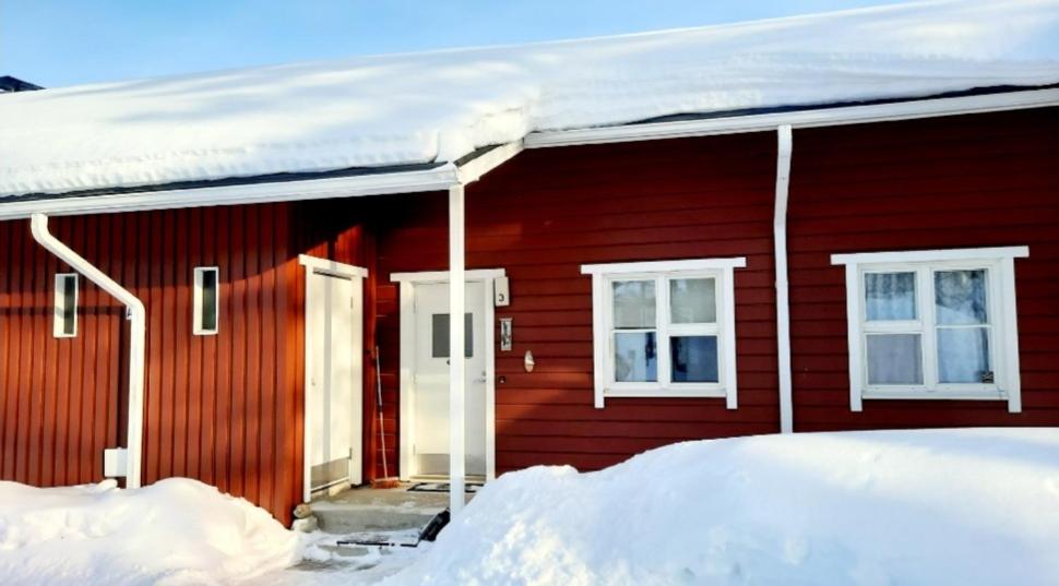 a red house with snow on top of it at Apartment Urupaa in Saariselka