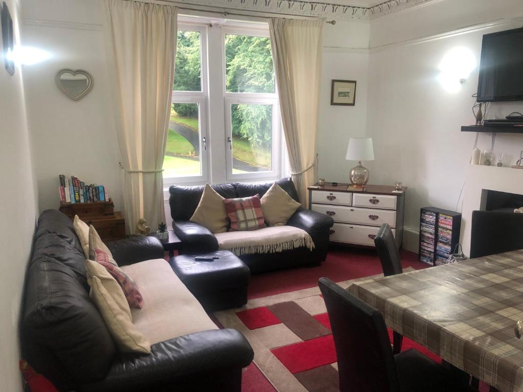 a living room with a couch and a table at Captivating 2-Bed Apartment in Isle of Bute in Rothesay