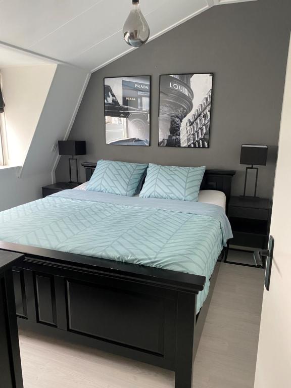łóżko w sypialni z dwoma zdjęciami na ścianie w obiekcie Het Dirkbosje w mieście Middelharnis