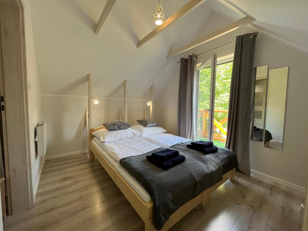 U Gruszków - domek pod Chojnikiem في يلينيا غورا: غرفة نوم بسرير وفوط سوداء عليها