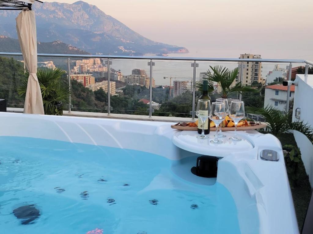 a swimming pool with a table with wine glasses on it at Apartman Marija in Becici