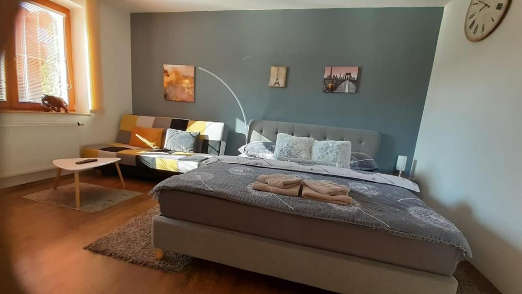 a bedroom with a bed and a couch at Green Apartment in Františkovy Lázně