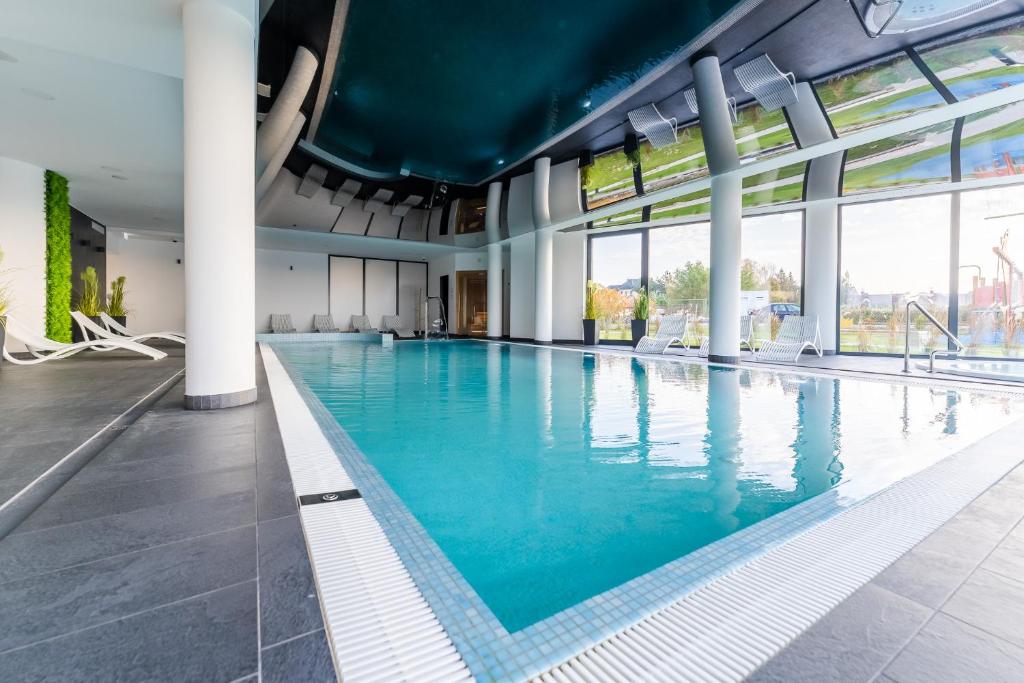 a large swimming pool with blue water in a building at Apartamenty Baltic Sea Westin House 404 in Kołobrzeg