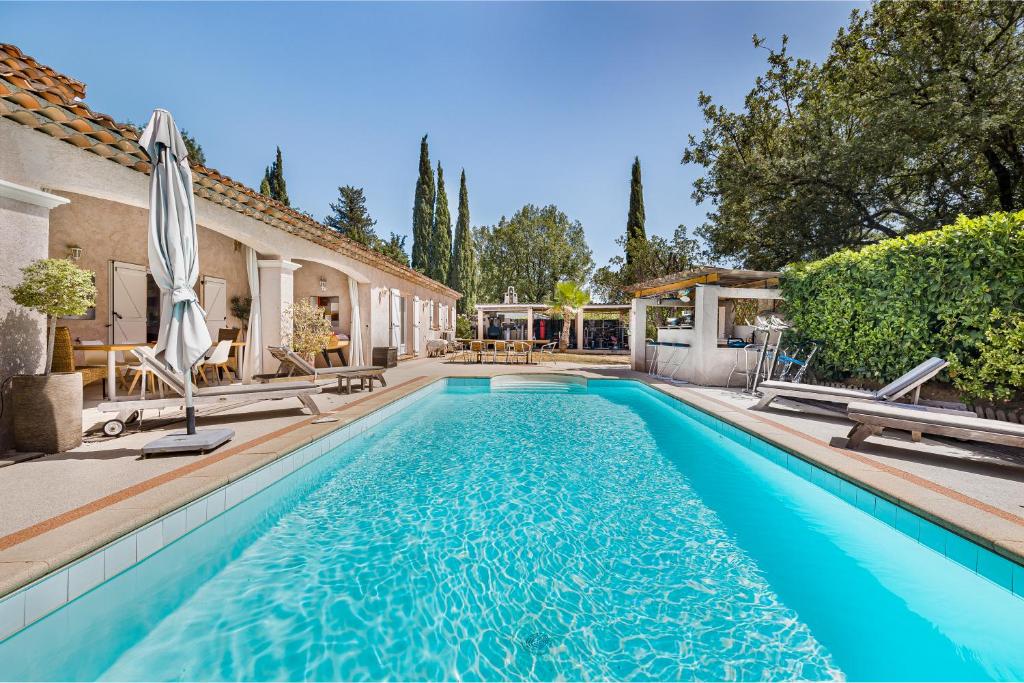 una piscina en el patio trasero de una casa en Villa Madiana -"La Perle et Le Diamant" idéale grande famille, groupe amis, salle fitness, Jardin, proche Cannes, Grasse, Antibes,, en Montauroux