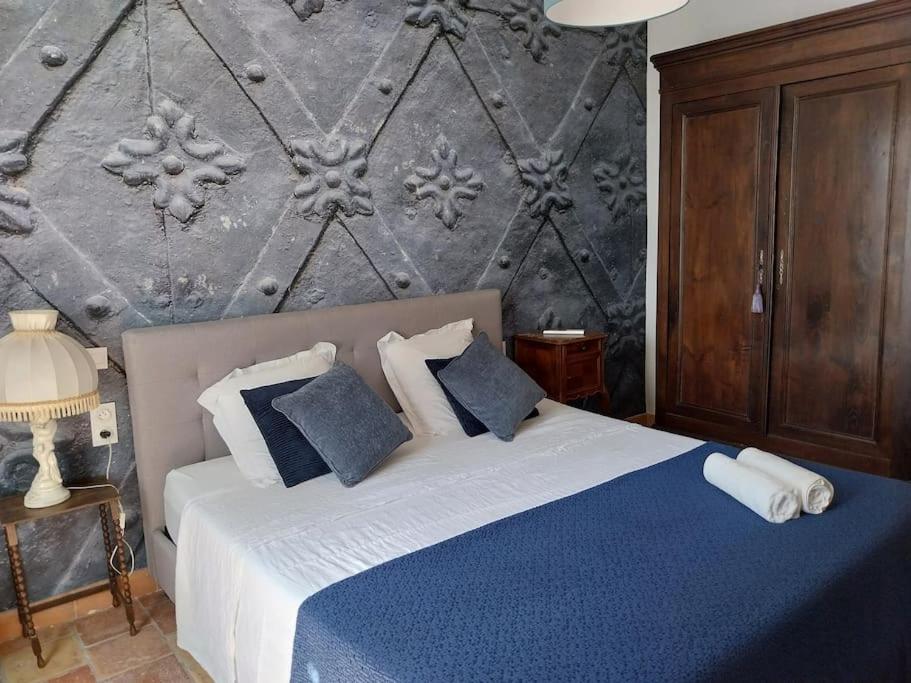 - une chambre avec un lit doté d'oreillers bleus et blancs dans l'établissement Château sur le Canal du midi proche de Carcassonne, à Trèbes