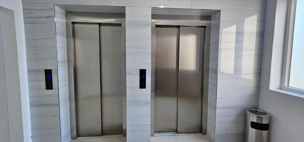 two elevator doors in a bathroom with marble walls at Superb 1 bedroom in the best zone of the city. in Ferizaj