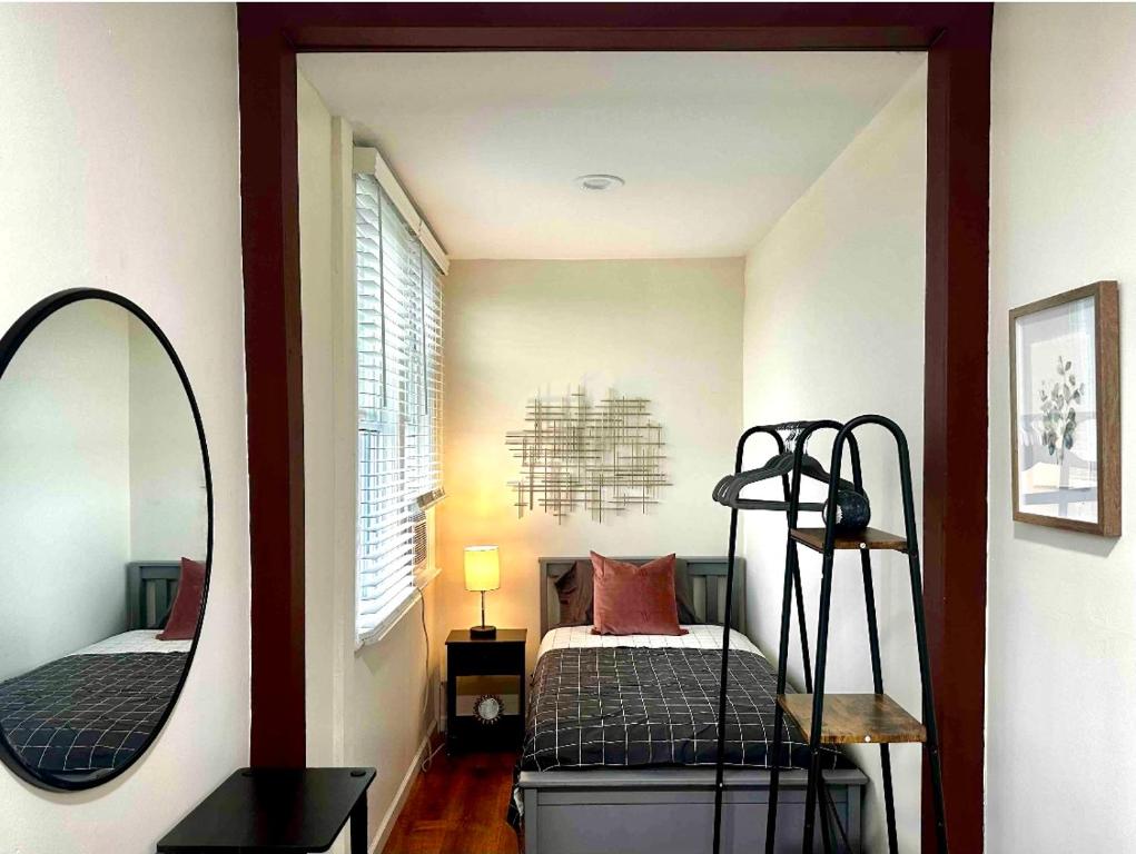 ein kleines Schlafzimmer mit einem Bett und einem Spiegel in der Unterkunft 0-A Diamond in Yonkers, NY in Yonkers