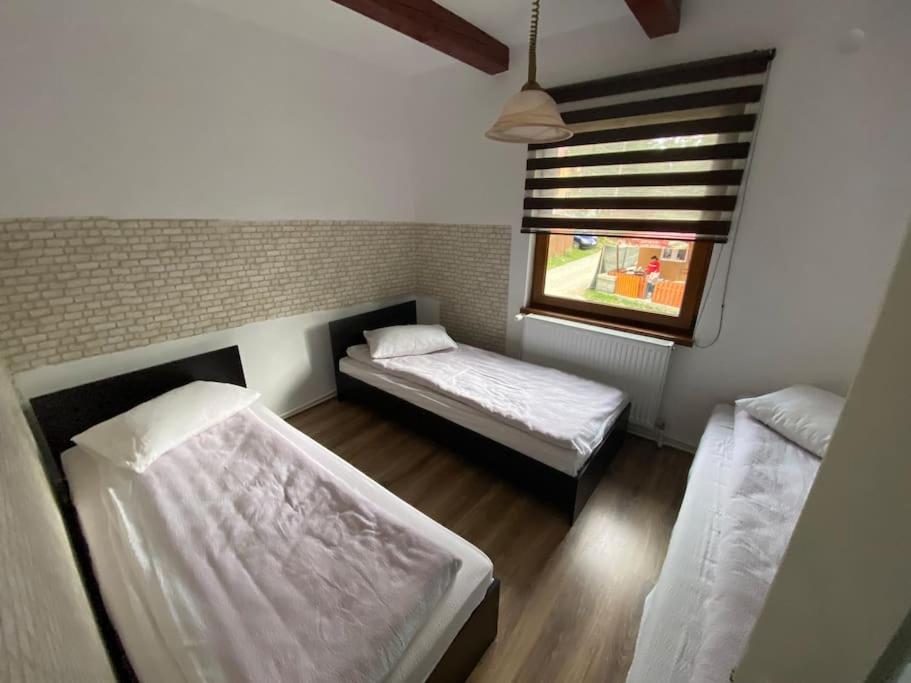 a room with two beds and a window in it at Casă de vacanță în zona montană in Sântimbru-Băi