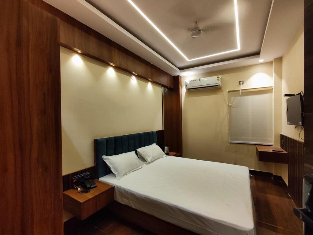 a small room with a bed and a tv at HOTEL B S HEIGHTS in Deoghar