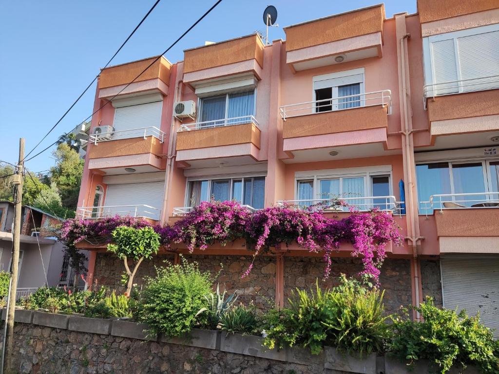 un edificio arancione con fiori viola sopra di Duplex House on the Castle Road with a Seaview a Alanya