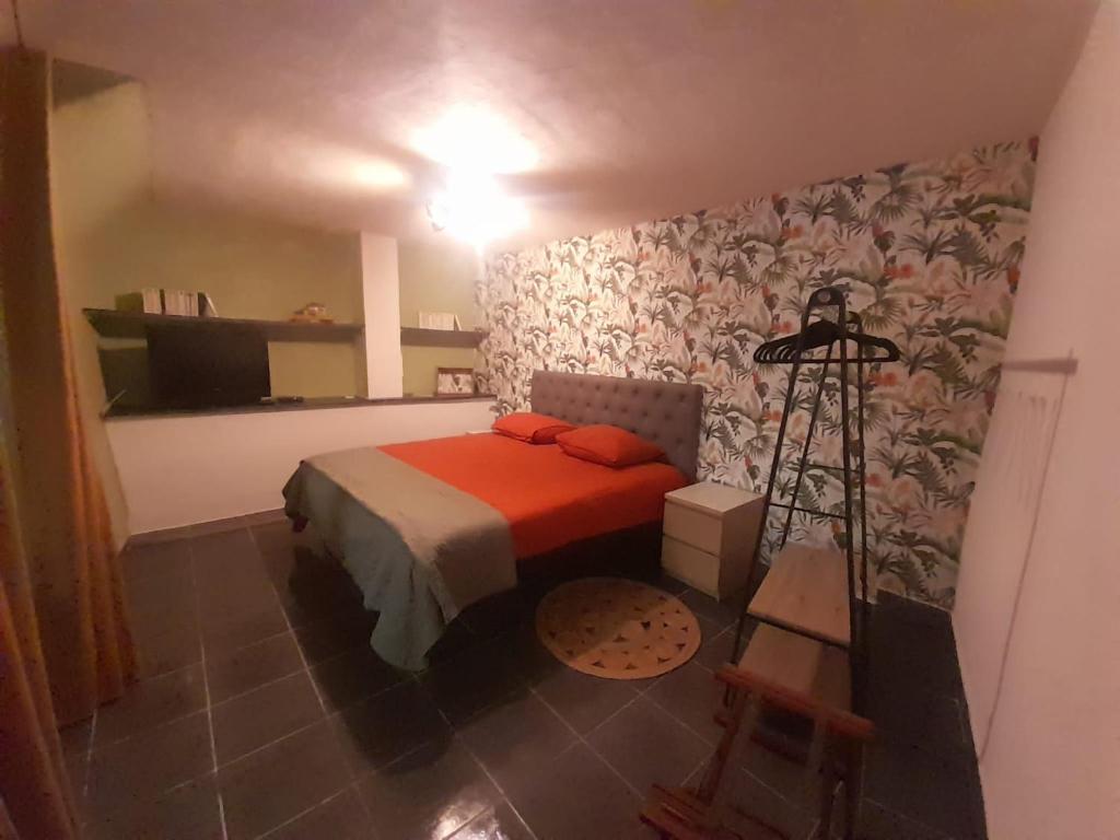 une chambre avec un lit avec une couverture rouge dans l'établissement Gîte Olivia, à Saint-Florent-sur-Auzonnet