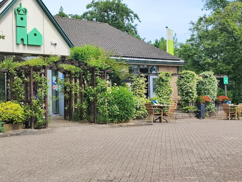 een gebouw met een patio met tafels en stoelen bij Campanile Hotel & Restaurant Vlaardingen in Vlaardingen