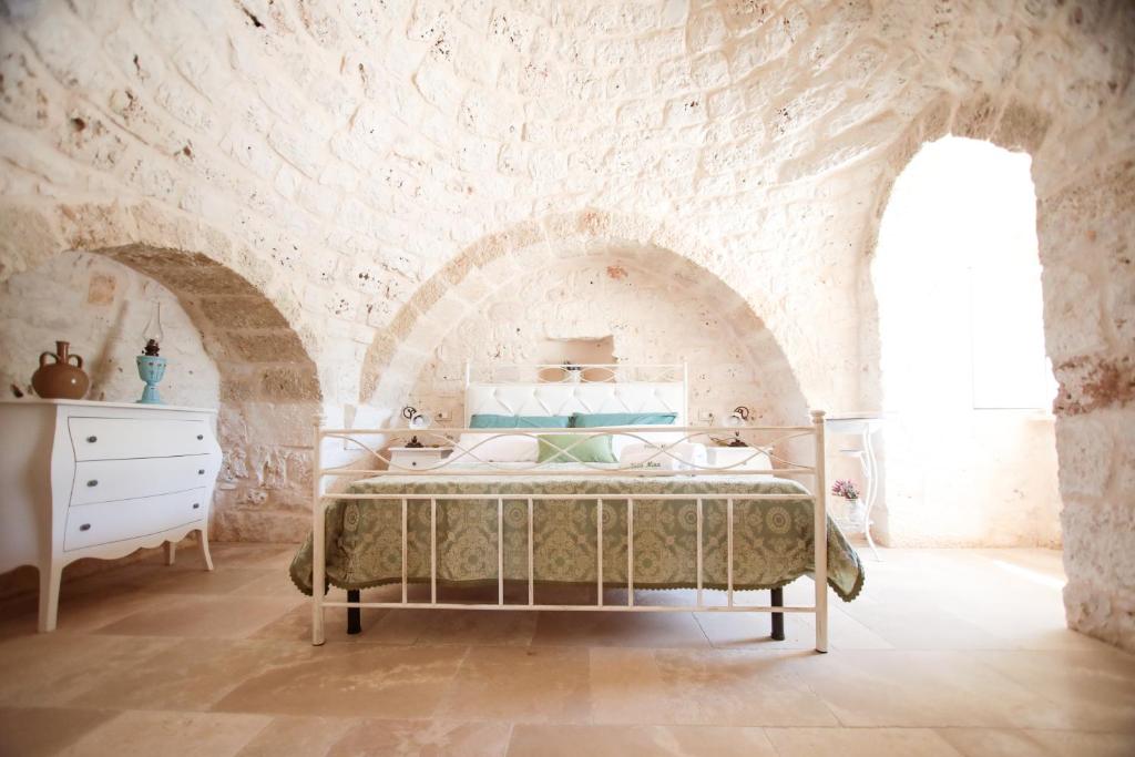 a bedroom with a bed in a stone wall at Villa Mina in Ostuni