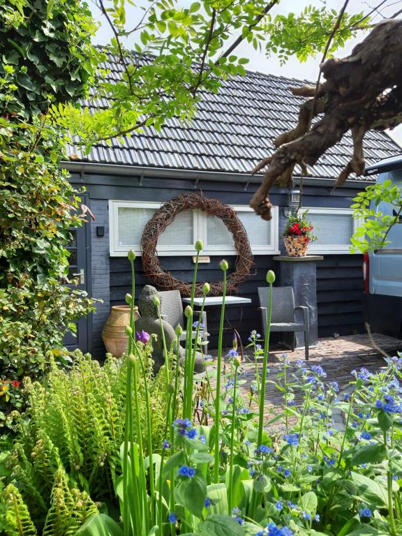 um jardim com mesa e cadeiras em frente a uma casa em Tuinhuis em Lutjewinkel