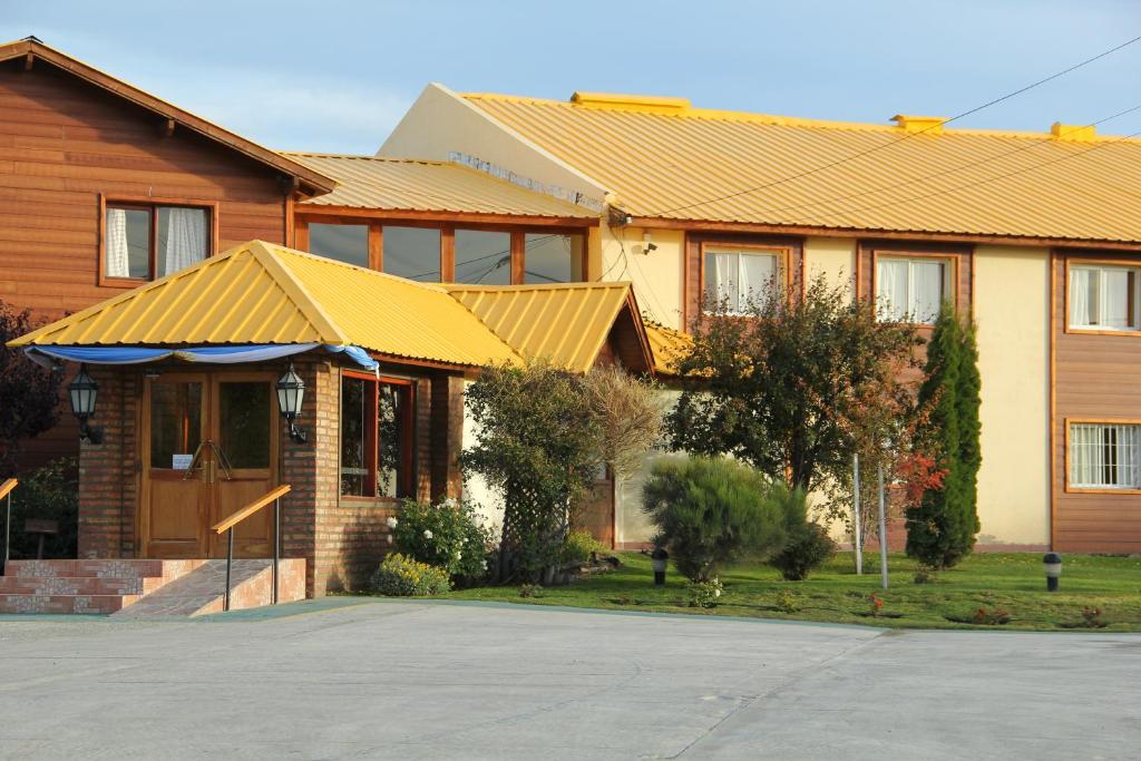 a house with a yellow roof and a driveway at Hotel Picos Del Sur in El Calafate
