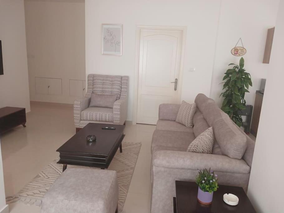 Zara's luxury Home- central location near Abdali في عمّان: غرفة معيشة مع أريكة وكراسي وطاولة