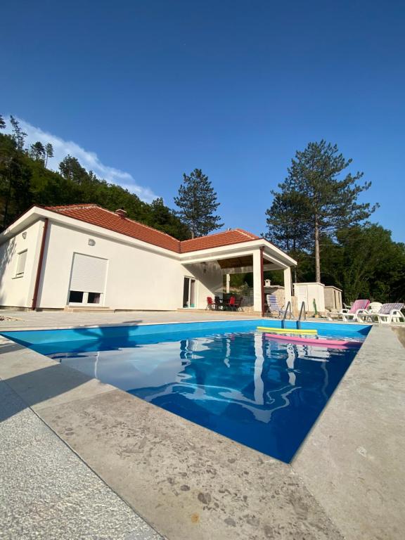 a swimming pool in front of a house at Vila Oaza in Trebinje