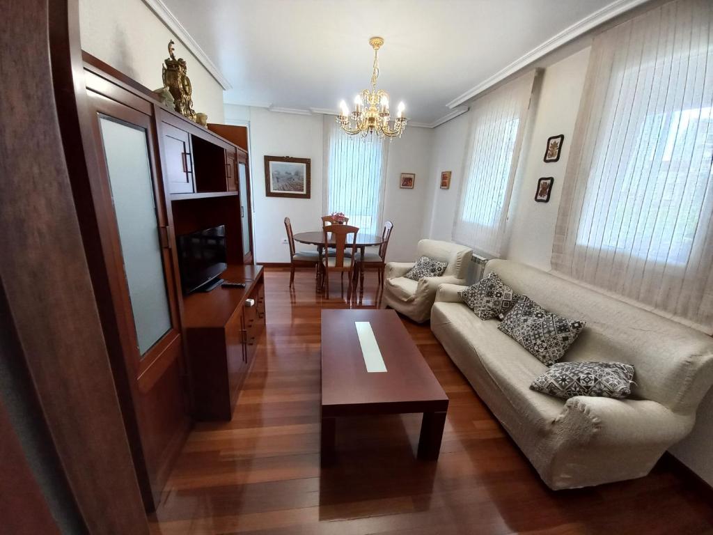 a living room with a couch and a table at Piso Villa Aurora in Carballino