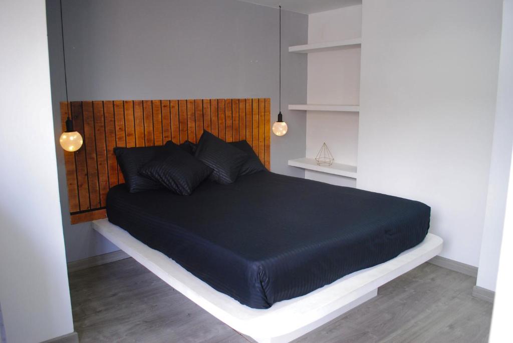 a bedroom with a black bed with a wooden headboard at Luxury 79 in Bogotá