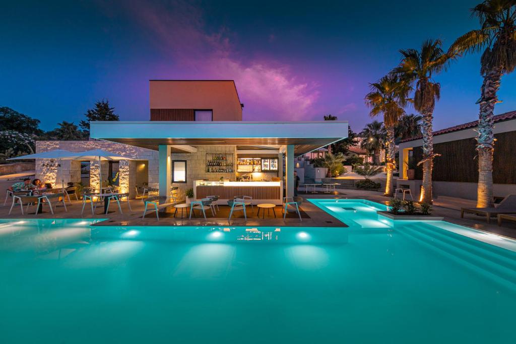 a house with a swimming pool in front of a house at Insulae Resort in Cefalù