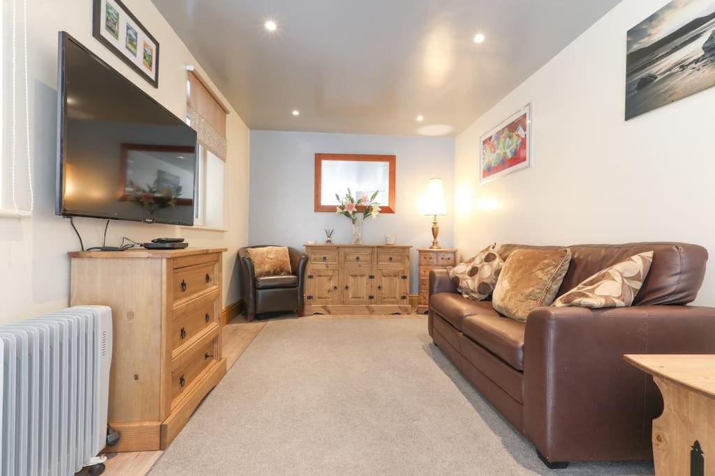 a living room with a couch and a flat screen tv at Wend Gardens, Carleton, Skipton. Pet friendly. in Skipton