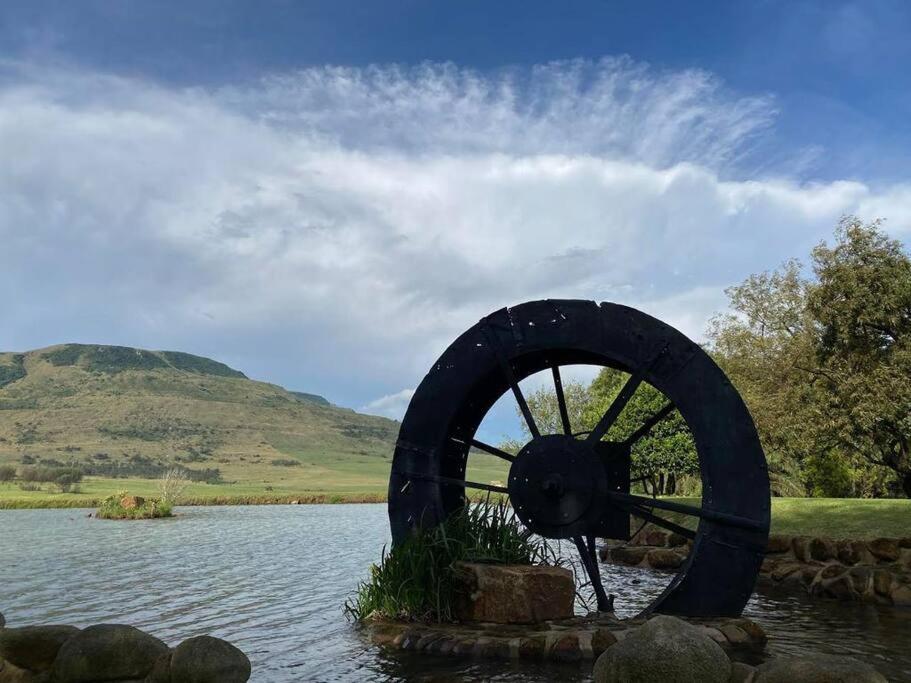 a water wheel in the middle of a body of water at The Water Wheel in Vryheid