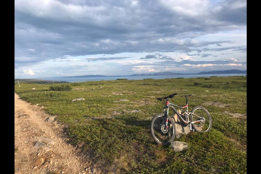 una bicicleta estacionada al lado de un camino de tierra en Leilighet i Vadsø en Vadsø