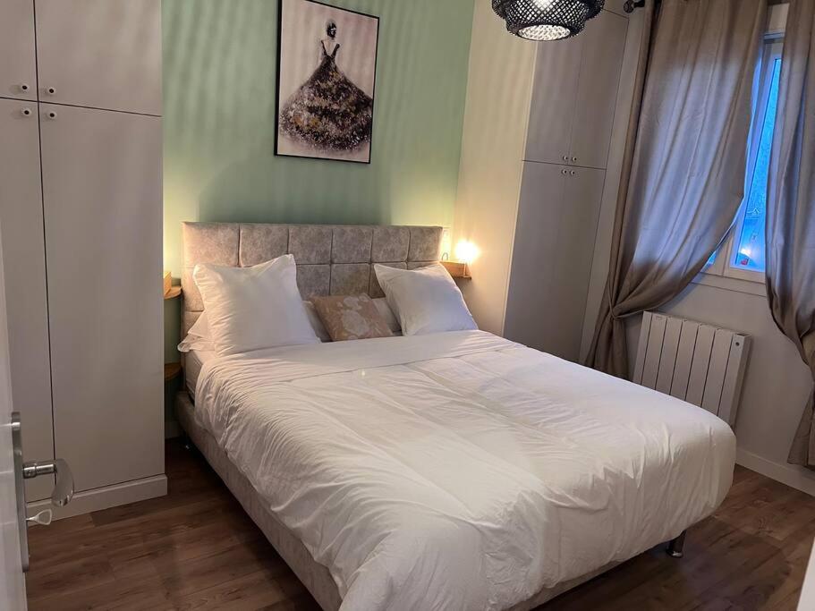- une chambre avec un grand lit et des draps blancs dans l'établissement APPartement 15 minutes de paris 2 bedrooms, à Drancy
