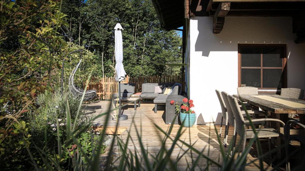eine Terrasse mit Stühlen, einem Tisch und einem Sonnenschirm in der Unterkunft Ferienhaus Sommerbichl in Zell am See