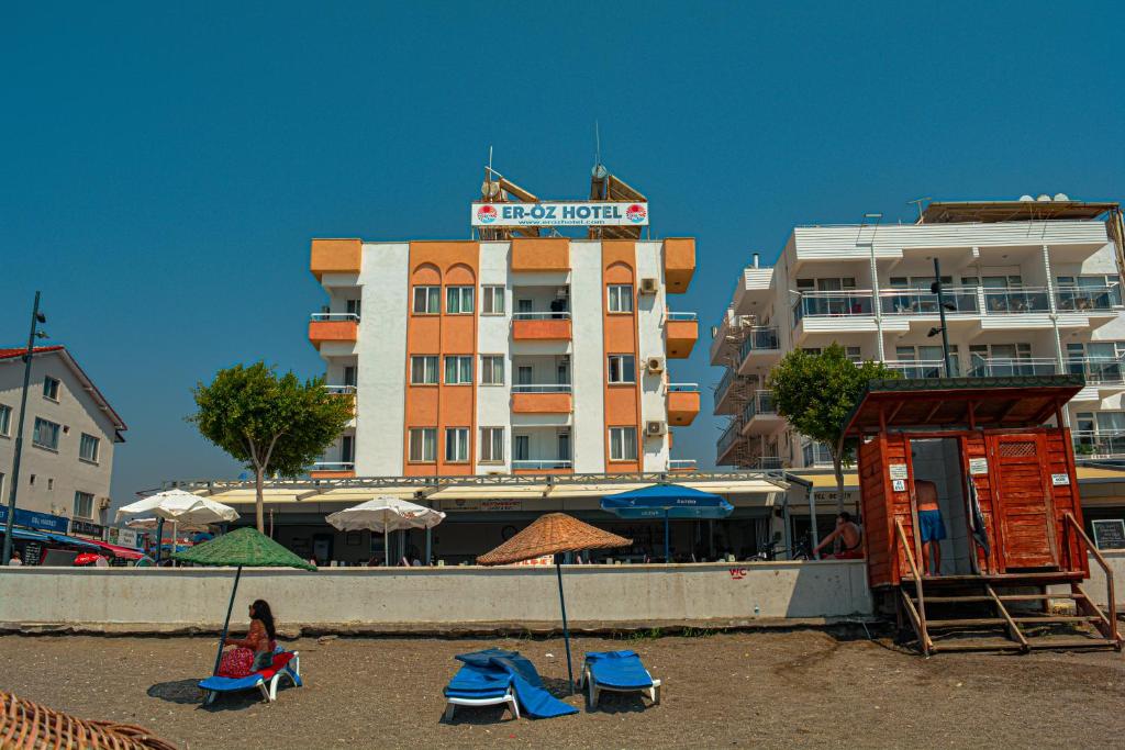a hotel on the beach with chairs and a building at Er-Öz Hotel in Fethiye