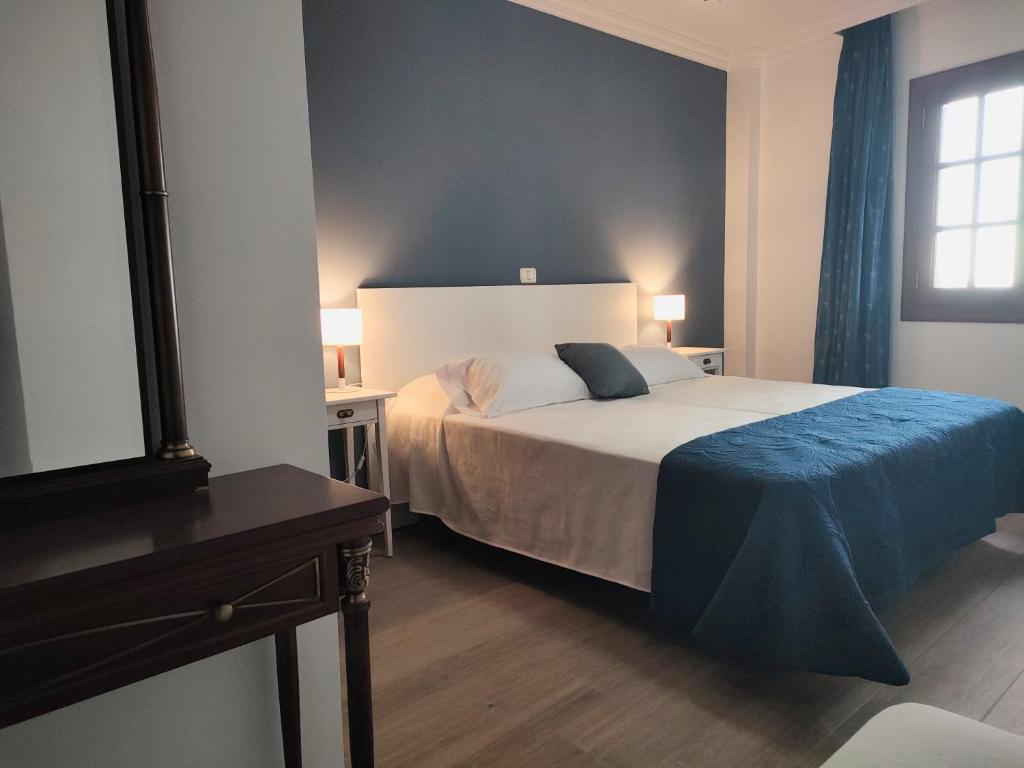 ein Schlafzimmer mit einem Bett mit einer blauen Decke darauf in der Unterkunft Come Together in San Juan de la Rambla