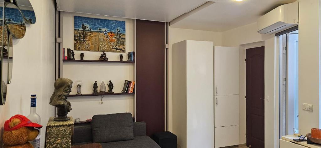 a living room with a couch and shelves on the wall at STUDIO 22M2 A IVRY/SEINE-A 200 METRES DE PARIS. PROCHE METRO 7 in Ivry-sur-Seine