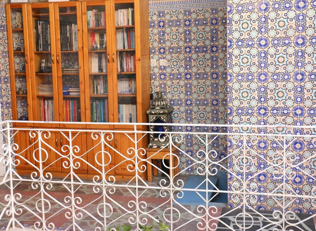 a balcony with a fence and a book shelf with books at Riad Les Chtis D'Agadir in Agadir