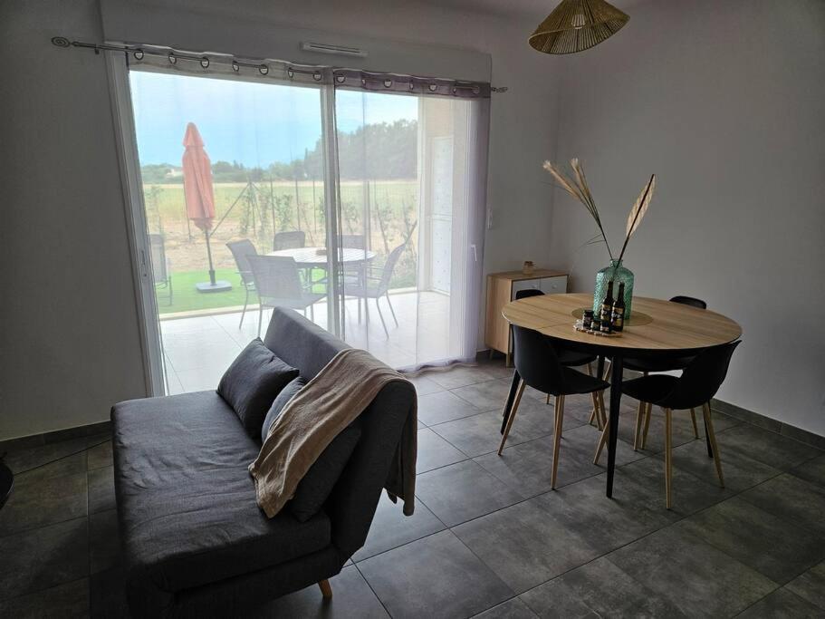 ein Wohnzimmer mit einem Sofa und einem Tisch in der Unterkunft Appartement neuf, rez-de-jardin in Lucciana