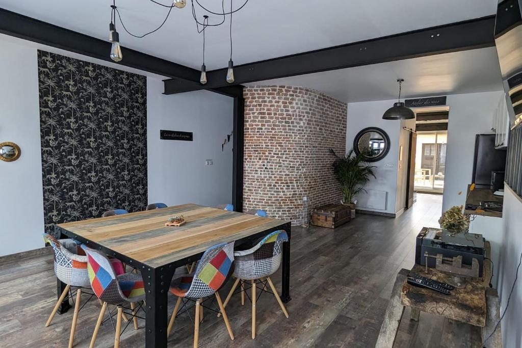 una sala da pranzo con tavolo e sedie in legno di Chez Pépère a Londinières