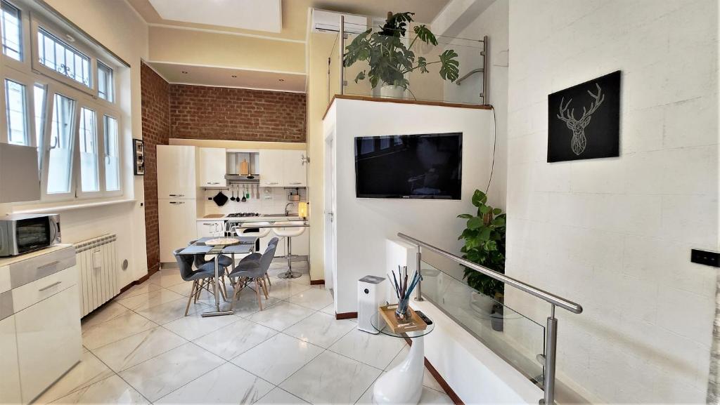 uma cozinha e sala de jantar com uma televisão na parede em Luxury Loft - Milano Centrale em Milão