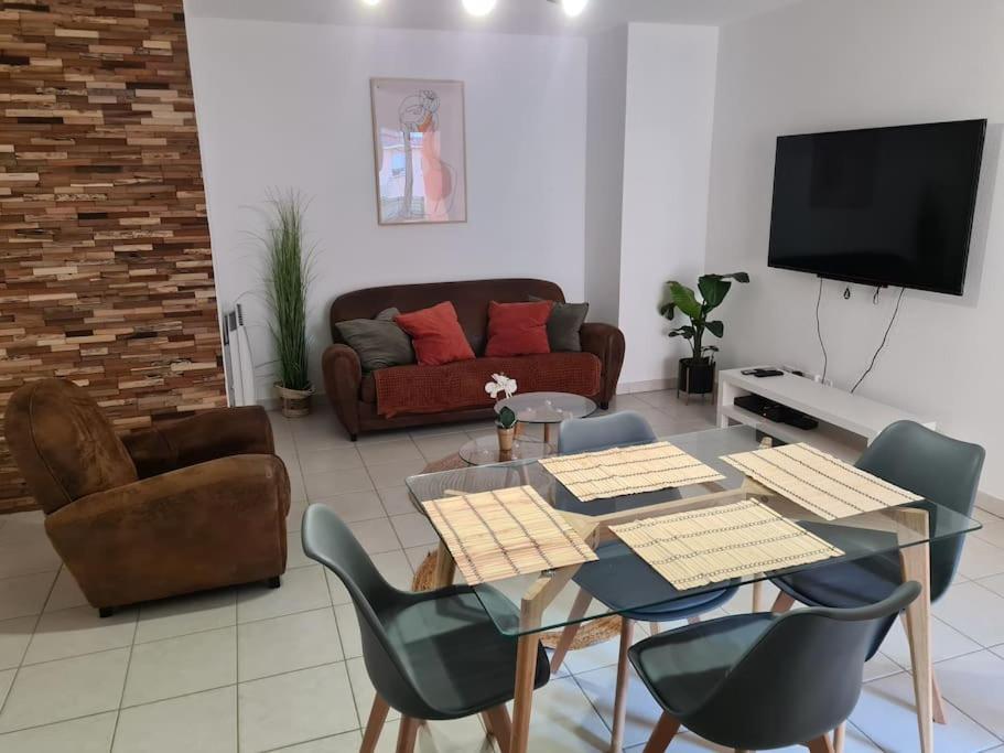 un salon avec une table, des chaises et un canapé dans l'établissement Les Capucins - Centre ville - Parking inclus, à Belfort