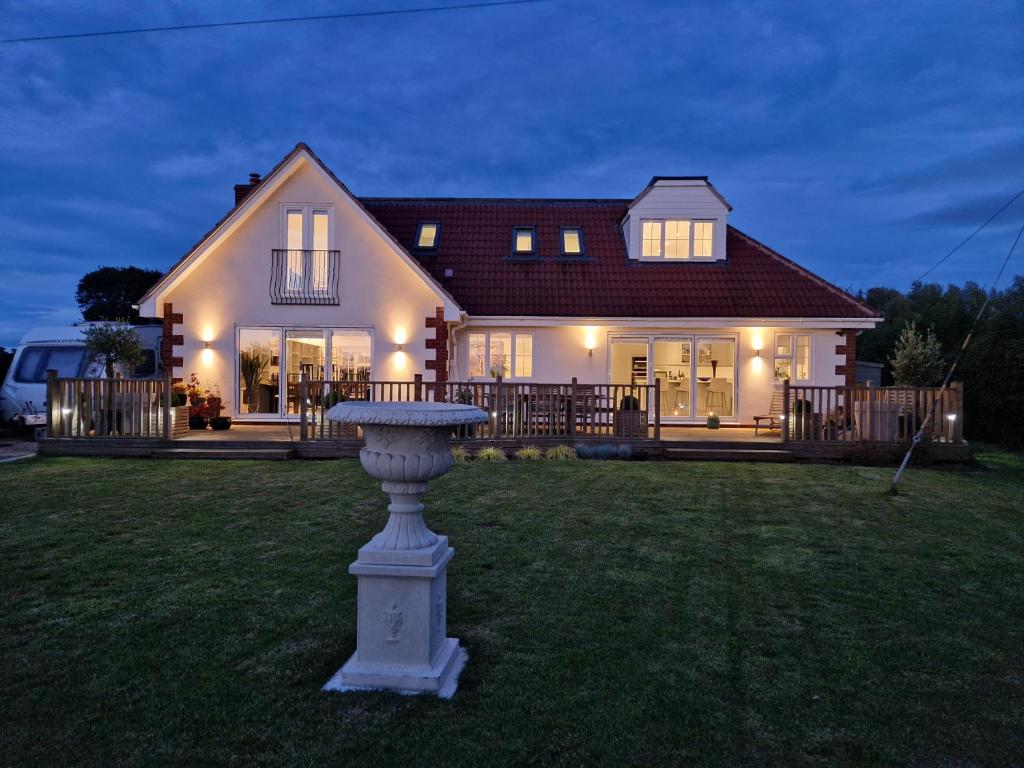 uma casa com um banho de pássaros no quintal em Hillvine em Hartpury