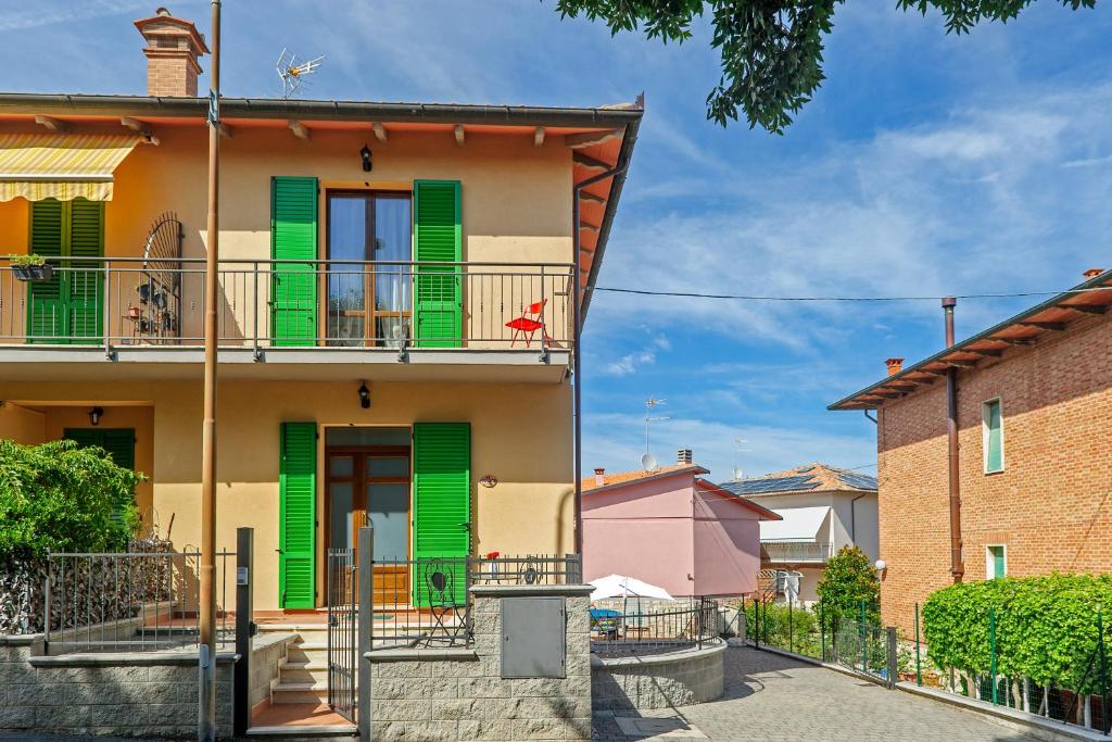 una casa con persiane verdi e balcone di CASA REFENERO a Torrita di Siena