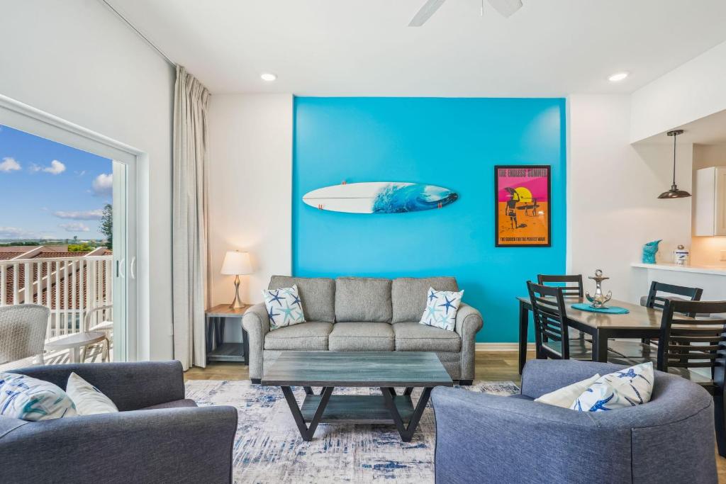uma sala de estar com um sofá e uma prancha de surf na parede em Madeira Bay Resort I 1505 em St. Pete Beach