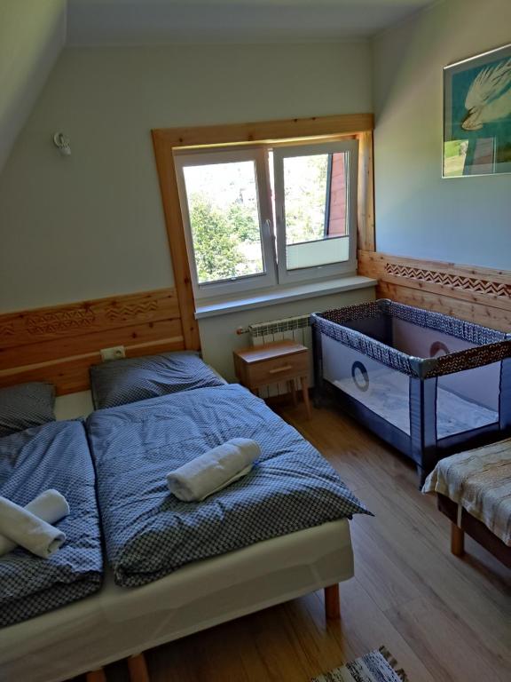 a bedroom with a bed and a tub in it at Dom W Krokusach Pokoje Gościnne in Nowe Bystre
