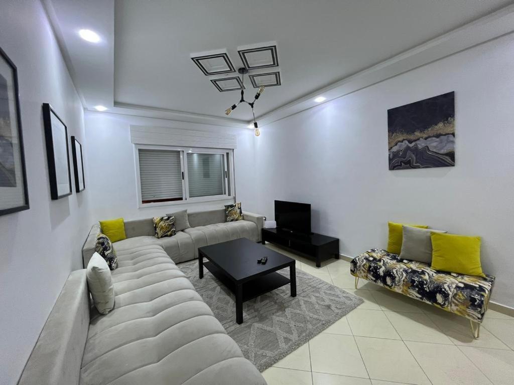 una sala de estar con un sofá y una mesa en Residence meaxpa adres Av Youssef ibn tachfine 4 Tanger, en Tánger