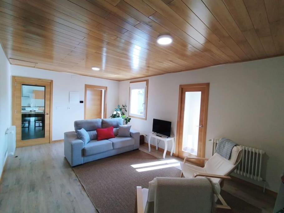 a living room with a couch and a tv at Vila María in Castrelo de Miño