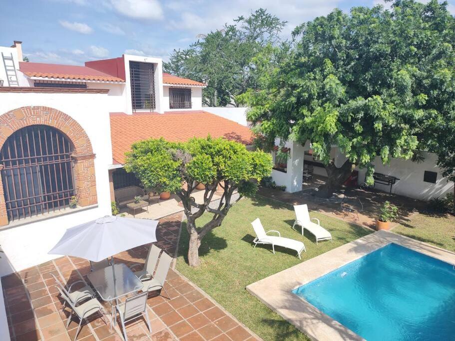 an overhead view of a backyard with a swimming pool and an umbrella at Hermosa casa en Cuernavaca cerca de los mejores restaurantes y plazas in Cuernavaca