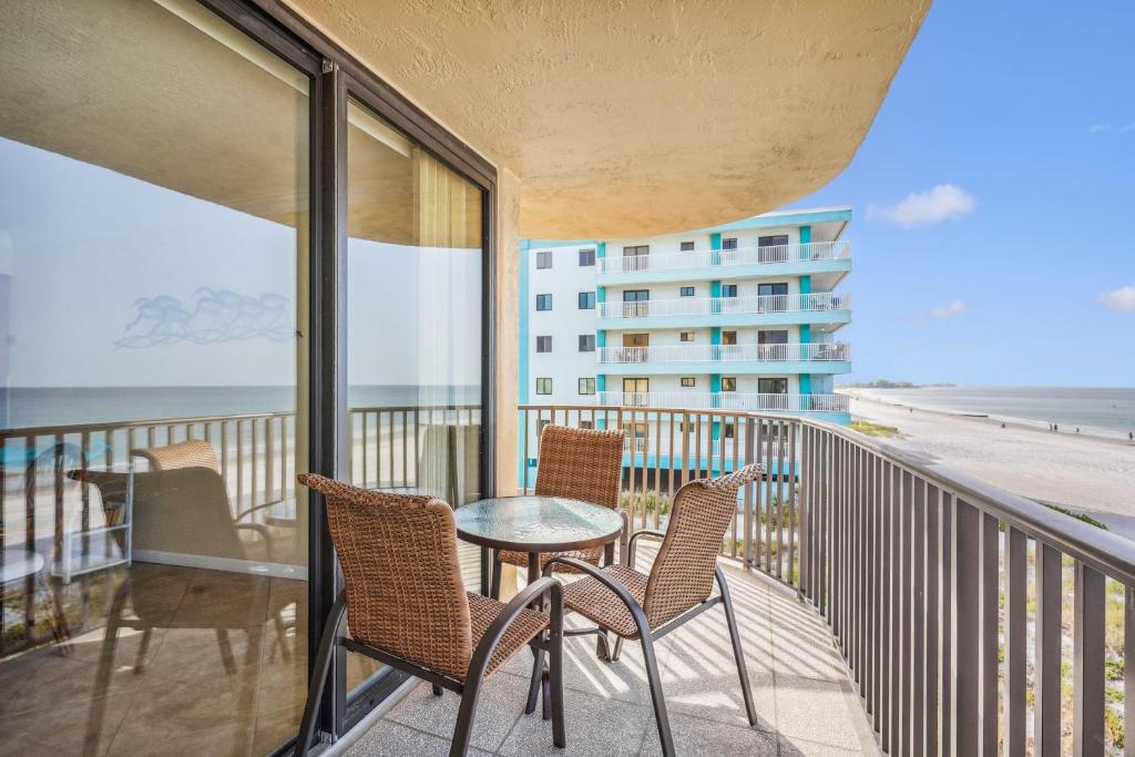 a balcony with chairs and a table and a view of the beach at Trillium 2A - Premier in St Pete Beach