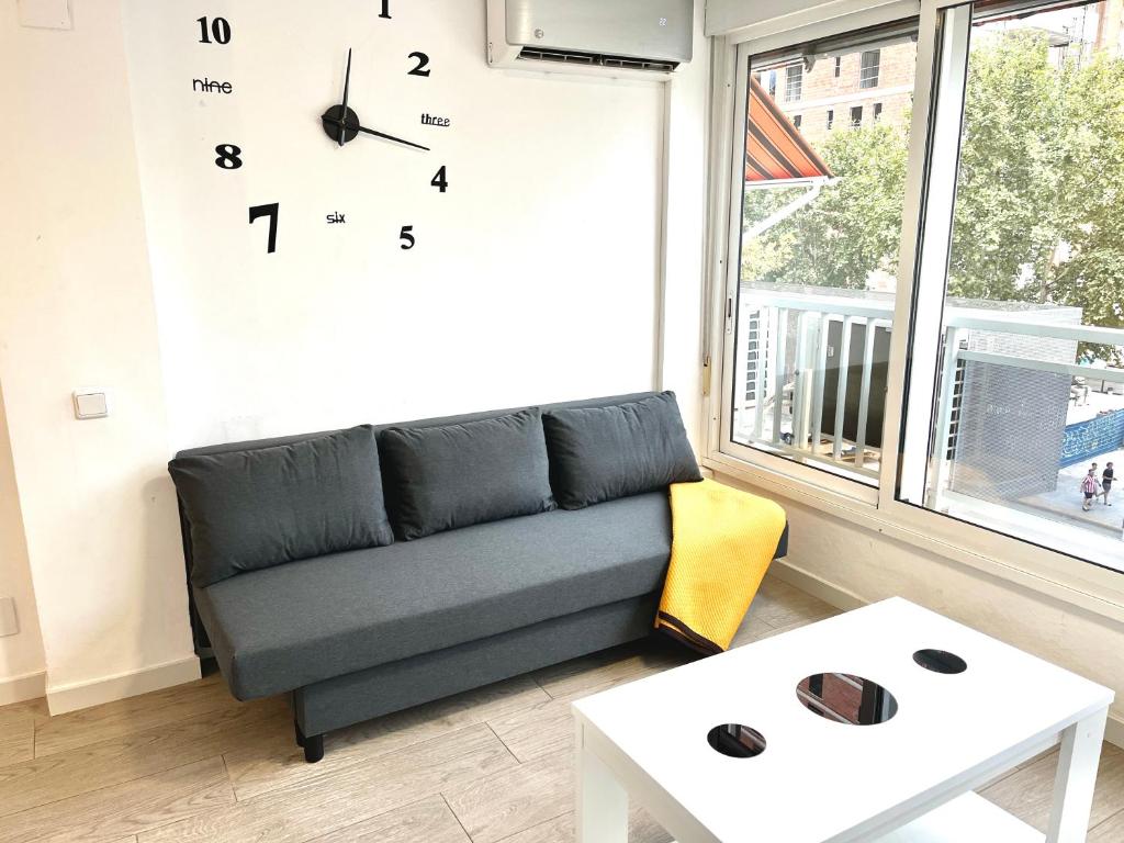 a living room with a couch and a clock on the wall at Apartment Ducado 41 Benidorm Playa levante 4 P in Benidorm