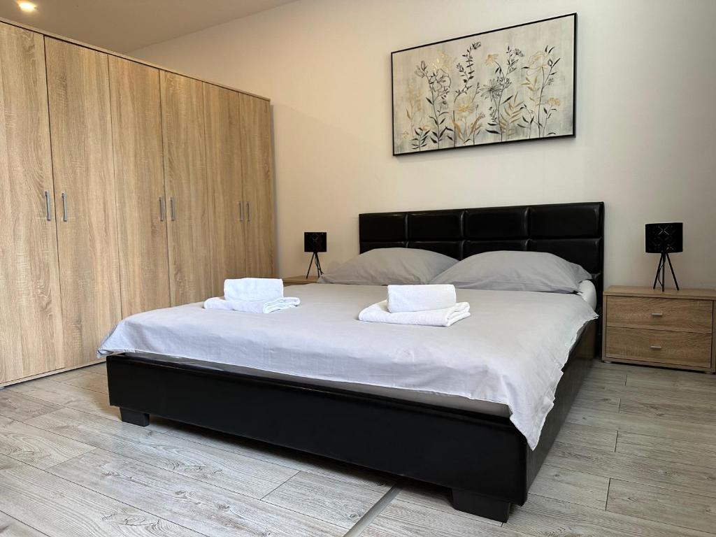 een slaapkamer met een groot bed en 2 handdoeken bij Apartmány Košice in Košice